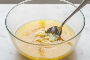 Geschmolzene Butter mit Knoblauch und Zitronensaft in kleiner Schüssel verrührt
