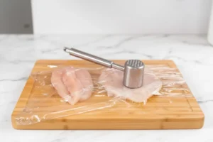 Rohes Hähnchenfilet, längs geschnitten und flach geklopft, gewürzt mit Salz, Pfeffer und Paprika